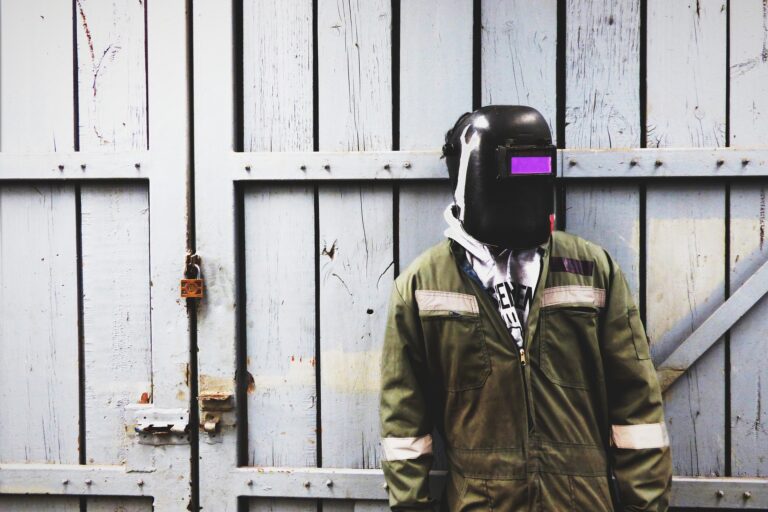 A man wearing a best welding shirt standing in front of a gate