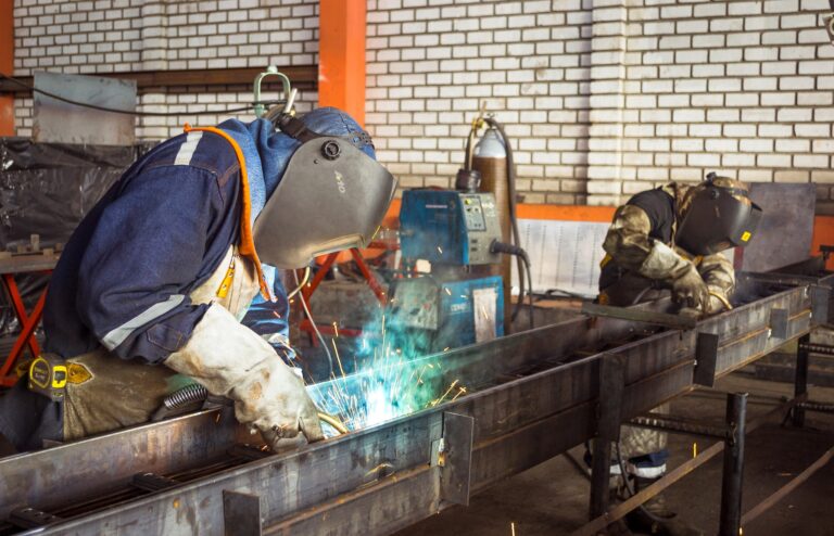 Welder wearing a black stallion shirt while welding