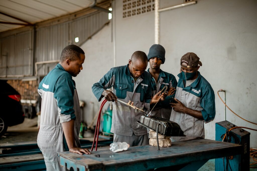 four welders wearing cotton welding shirt working on a project