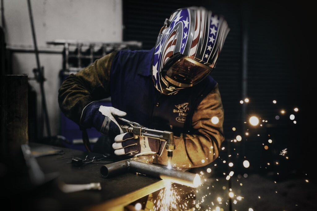 Masked Welder wearing a Welding Jacket for Men, while working