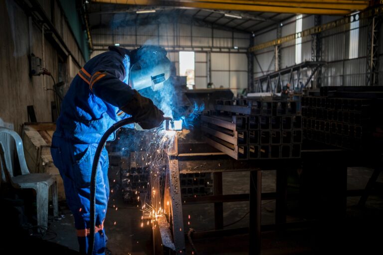 Welder wearing black stallion FR coverall, on his welding job site